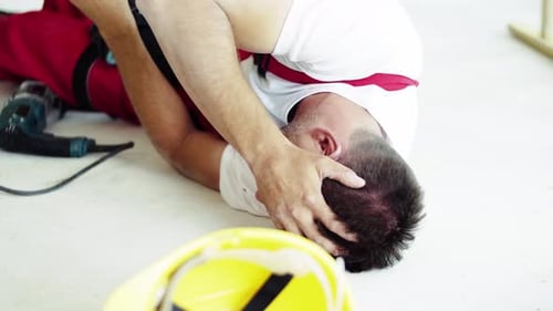 Construction Worker Injury: Man Lying on Floor After Accident