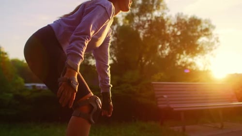 Unrecognizable young woman rollerblading in the park during suns