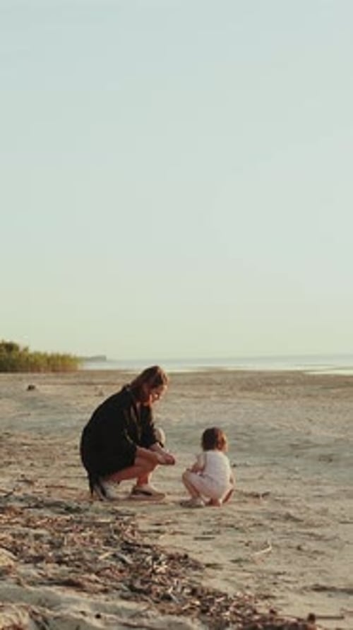 Vertical Video A Mother and Her Child Enjoying a Serene Day at the Beach Creating Lasting Memories