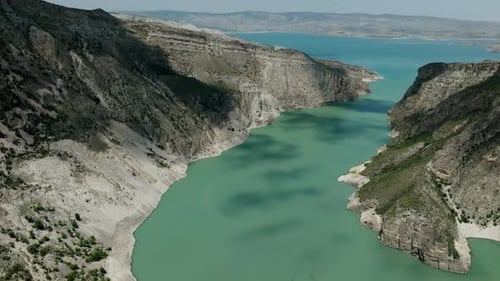 Un río serpenteante serpentea a través de un paisaje escarpado que se abre paso a través de montañas y acantilados