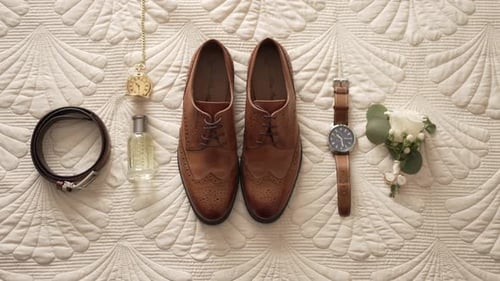 Men's Wedding Accessories Lay on Patterned Bed