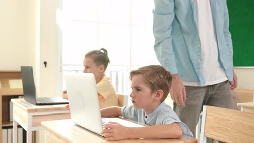 Caucasian teacher helping american student coding engineering prompt. Pedagogy.