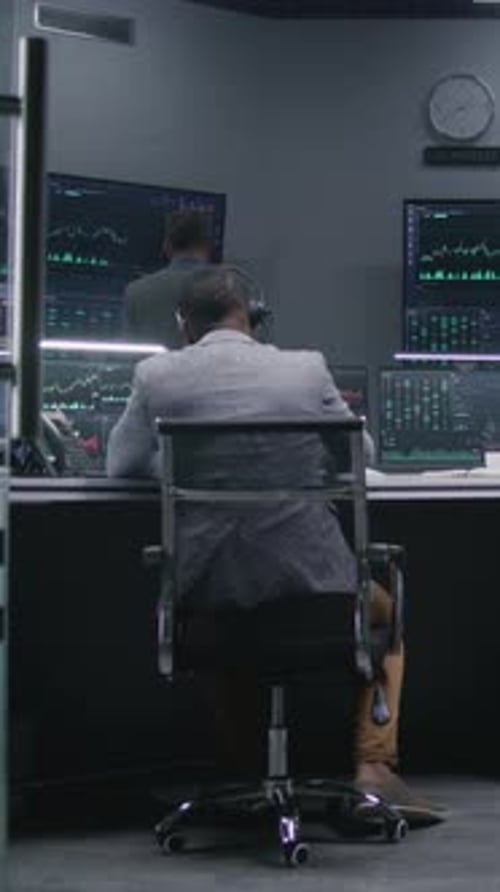 Analistas trabalham no computador com ações exibidas