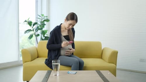 Pregnant Woman Examines Medicine in Bright Room