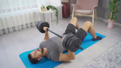 Man Lifting Weights During Workout in Living Room