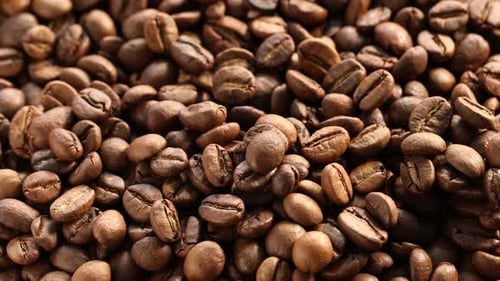 Pile of aromatic coffee beans as background, above view