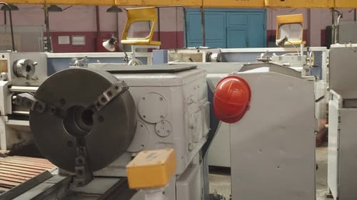 Worker Safety Helmet Hangs Near Powerful Lathe in Empty Old Factory