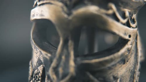 A close up detailed slow tilt up shot of a spartan face design, warrior ancient greek bronze helmet,