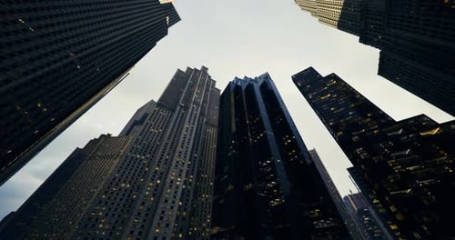 Vista de rascacielos bajo un cielo nublado en un entorno urbano durante el crepúsculo