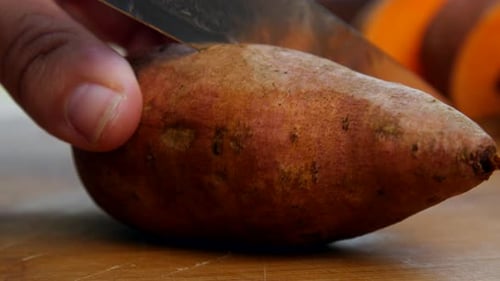 Slicing a Sweet Potato on Cutting Board