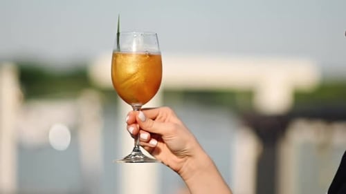 A girl holding a beautiful refreshing cocktail against the backdrop of the sea