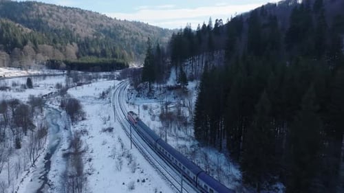 Train passing through snowy terrain in a scenic mountainous region