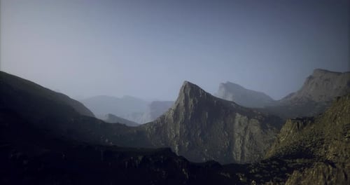 Dramatic Mountain Landscape with Misty Valleys and Distant Peaks at Dusk
