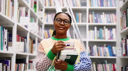 Portrait of African American Female Student with Books in the Library