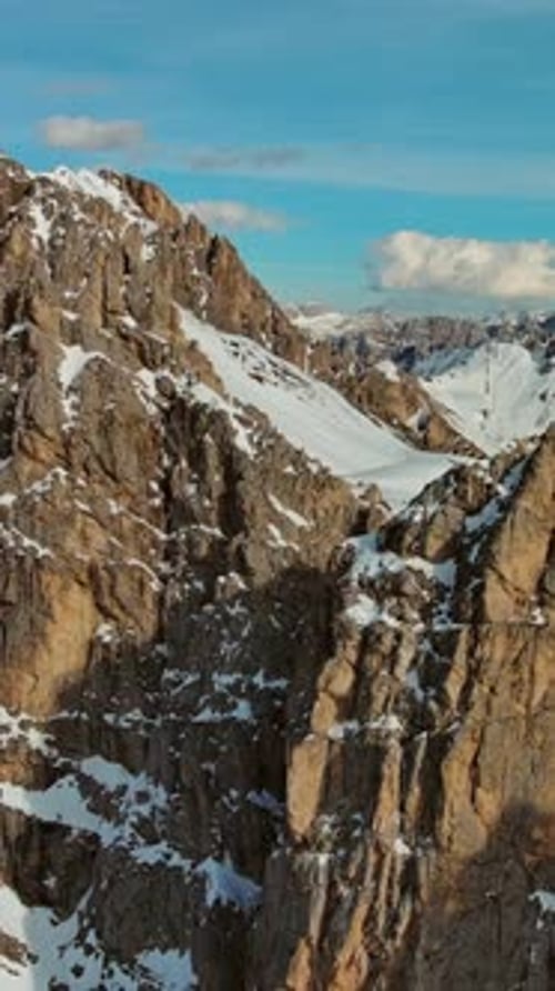 Rocky snow mountains at sunset aerial