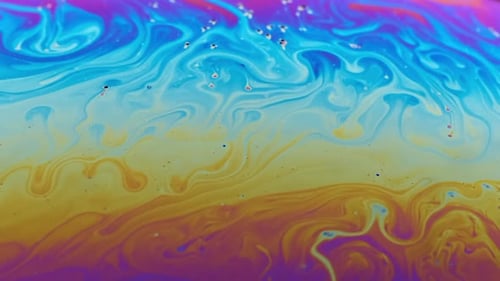 Close-up footage of the colourful surface of a soap bubble