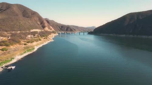 Aerial drone flying over a lake, water dam, with mountains at sunrise. Beautifull dreamy landscape v