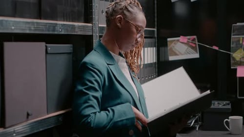 Focused Woman Reviews Documents in Dark Office