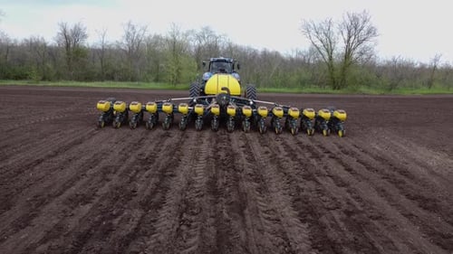 Blue tractor OA working on the field in Ukraine