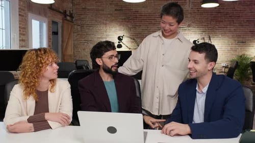 Diverse Team Collaborating on Laptop in Modern Office
