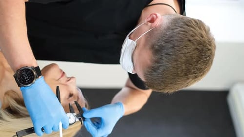 Medical Professional Using Calipers on Woman's Face