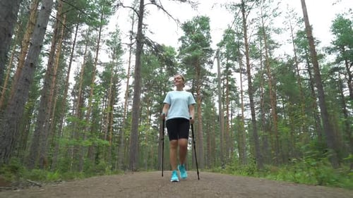 Active Woman Doing Nordic Walking in a Park