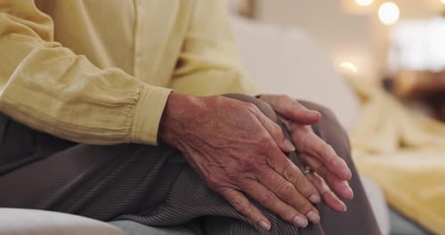 Relax, hands and senior man with knee pain, injury or muscle sprain in living room at nursing home