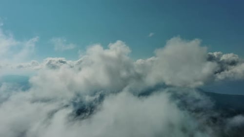 Aerial View of White Clouds Over Lush Mountain Forest