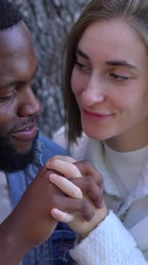 Dois amantes multiétnicos abraçados em um parque