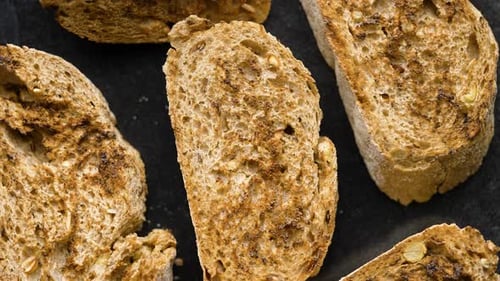 Toasted Baguette Slices Isolated on Dark Background Close Up