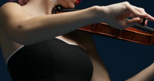 Woman Playing Violin Close Up on Dark Blue