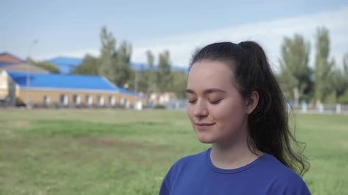 Woman Drinking Water from a Bottle Outdoors