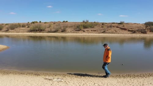 Man Walking By The Lake