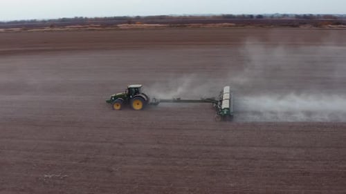 Luftbild eines Traktors bei der Arbeit im Frühlingsfeld. Vorbereitungszeit der Aussaat. Schießen aus einem Drohnenflug