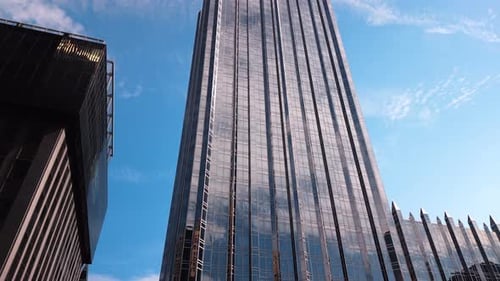 Blick auf das atemberaubende Hochhaus mit Glasfassade vor dem Hintergrund des blauen Himmels.