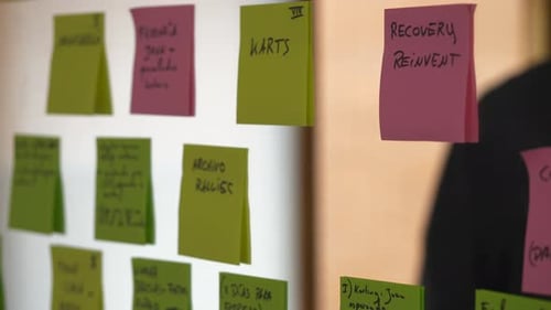 Closeup of hand sticking pink post-it note with word conclusion on glass surface