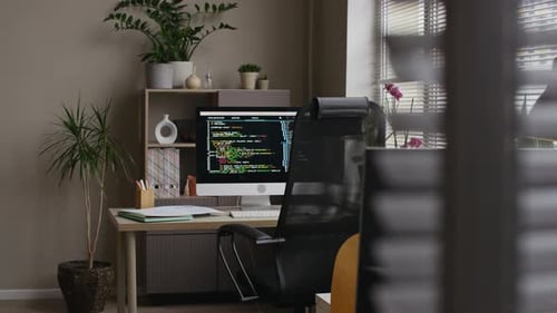 Büroarbeitsbereich mit Codierungsbildschirm auf dem Computerbildschirm