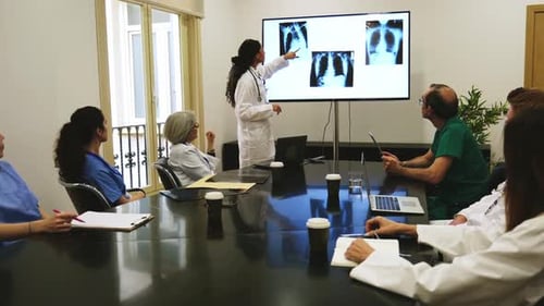 Medical Team Meeting and Reviewing X-Rays in Conference Room