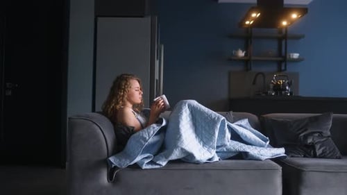 Sick Woman Coughing on a Sofa, Indoors