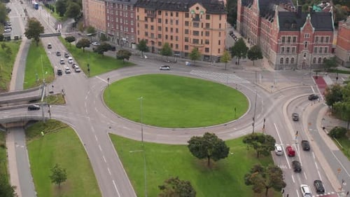 Traffic driving in roundabout in Roslagstull, Stockholm, Sweden. Drone footage mid day orbiting view
