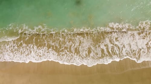 Awesome aerial view of sand beach and white crested waves