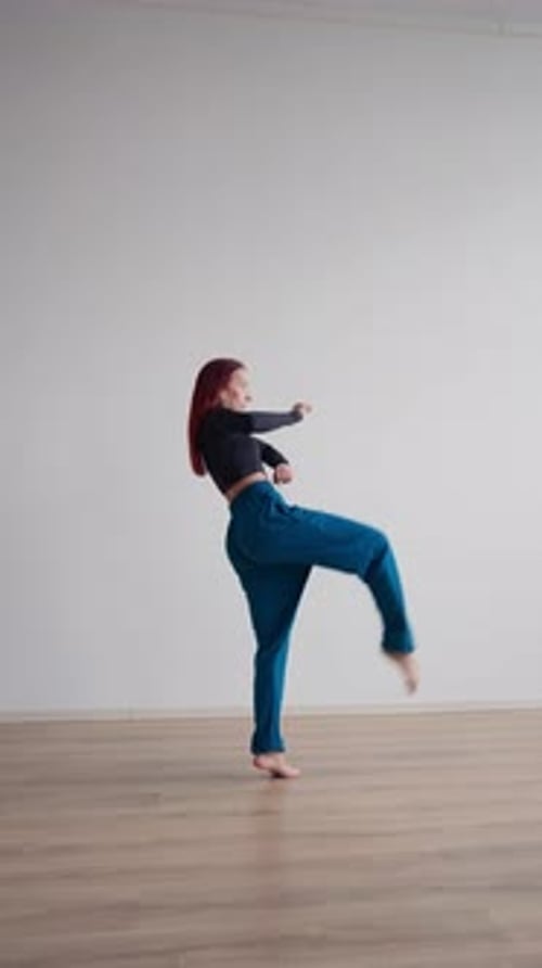 Athletic Woman with a Steep Stretch in Sportswear Performs Splits While Standing