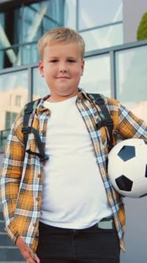 Portrait of Middle School Preteen Student Child Boy with Backpack and Soocer Ball Looking at Camera