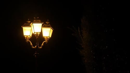 View of a spooky retro street lamp on a dark urban street.