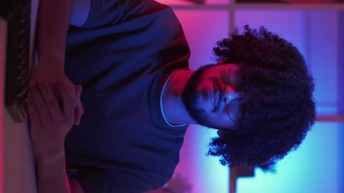 Young Man with Curly Hair in Neon Lighting