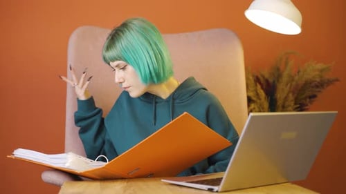 Woman Works With Laptop and Paper Documents at Home