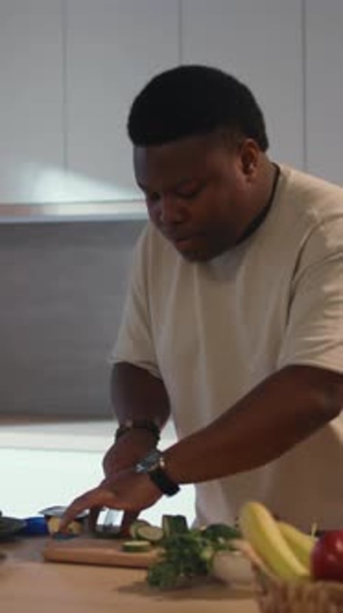 Attractive African American Man Cook Dance in the Kitchen at Home Preparation Breakfast Cut Cucumber