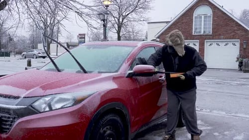 Adult Man De-Icing Car in Winter Weather