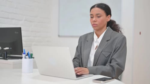 Young Woman Working on Laptop in Office