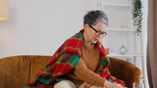 Woman with Headache Takes Pill at Home